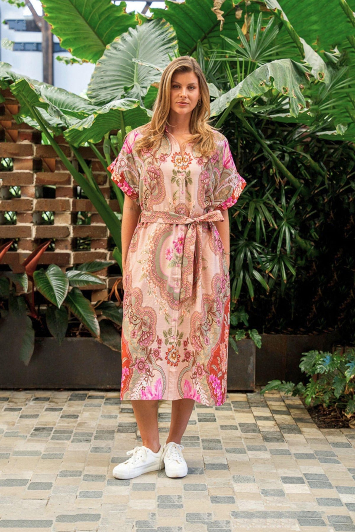 Fionn Midi Dress Boho Australia — full-length front view of the belted pink patterned midi dress beside greenery, available in Australia at Kat and Ko Clothing