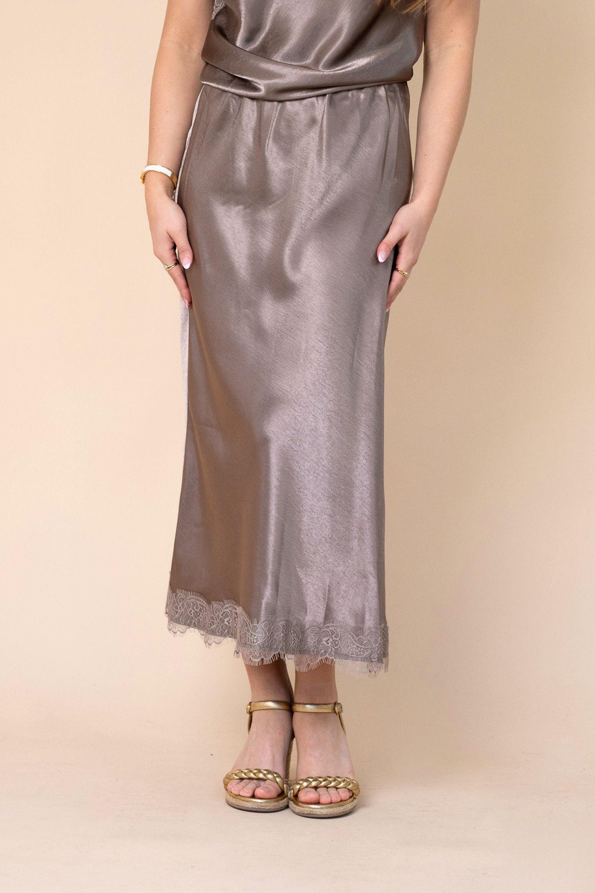 Fria The Label Bardot Satin Midi Skirt in Taupe front view from the waist down with lace-trimmed hem