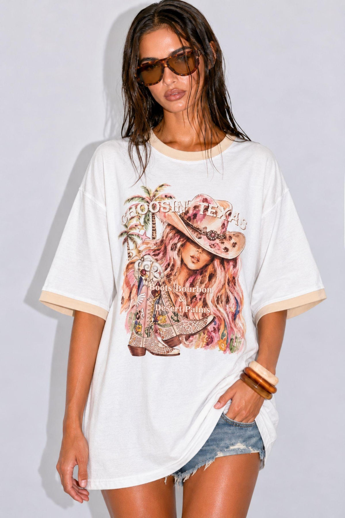 Coco Cartel Choose Texas Tee in White front view, oversized fit with cowgirl graphic, worn with denim shorts