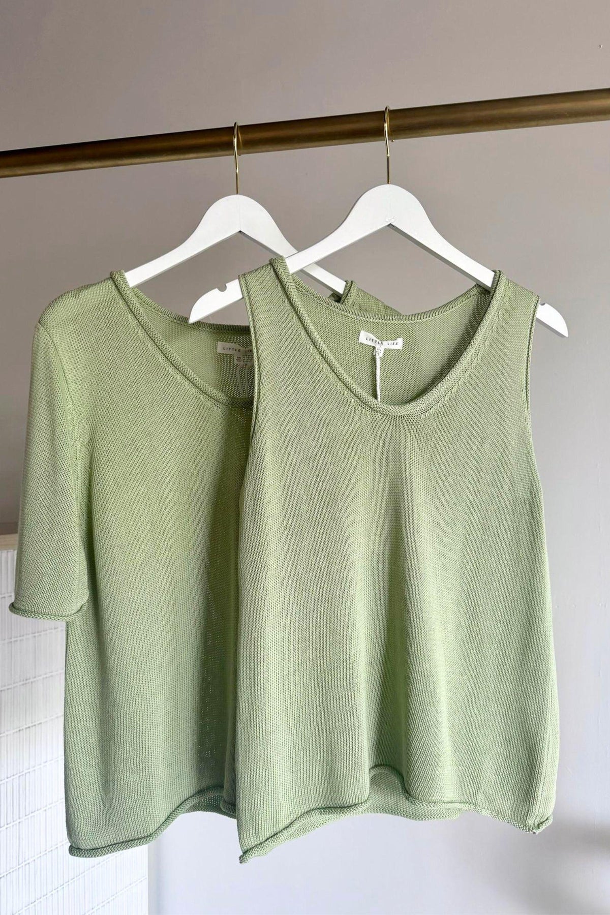 Little Lies Scoop Spring Tank in Sage on a hanger, layered in front of a matching sage tee