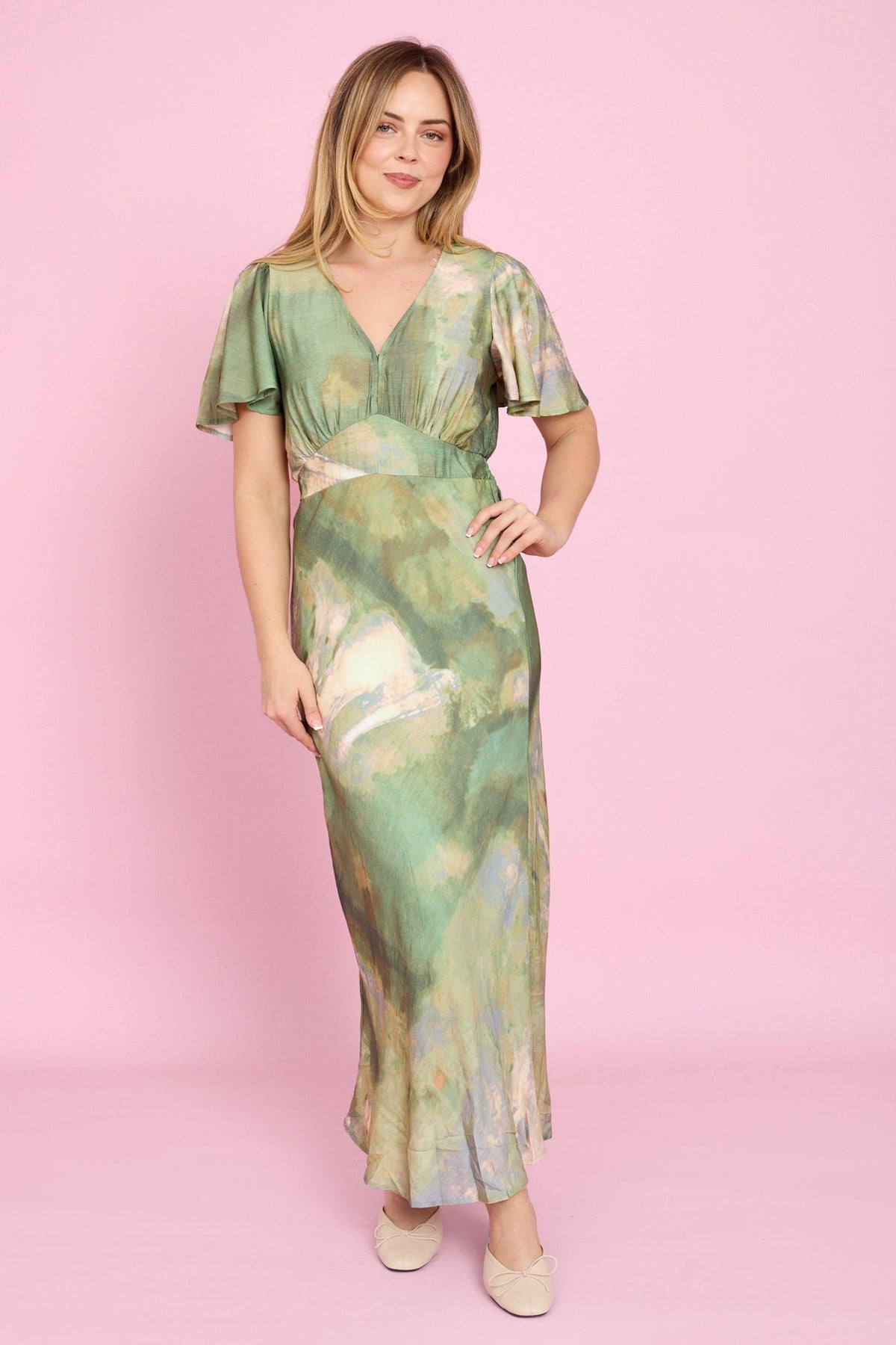 Fria The Label Dune Print Midi Dress in Sage front view with hand on hip, showing the abstract print