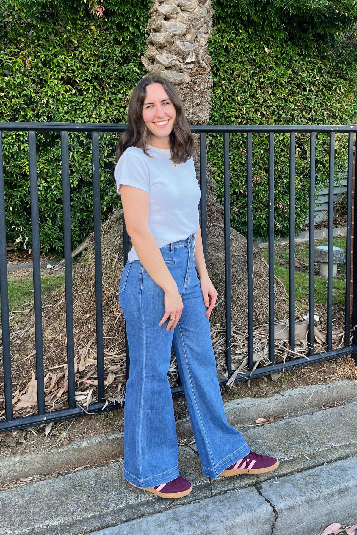 Wakee Jeans Derby Jeans Light Denim — angled front lifestyle shot of wide-leg light wash high-waist denim jeans showing front pocket detail, styled with a white classic tee and burgundy sneakers, available in Australia at Kat and Ko Clothing