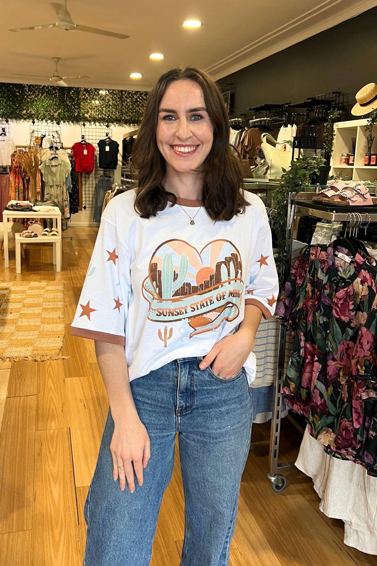 Sunset State of Mind Tee - White, Coco Cartel, front view with the white graphic tee partly tucked into blue jeans, available in Australia at Kat and Ko Clothing