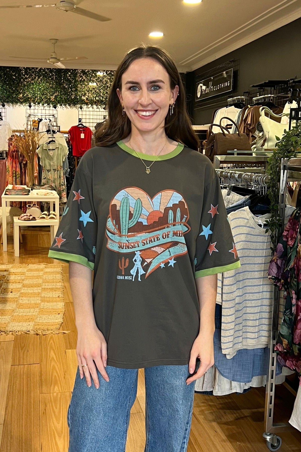 Coco Cartel Sunset State of Mind Tee - Charcoal, full-length front view of the charcoal graphic tee worn with blue jeans, available in Australia at Kat and Ko Clothing