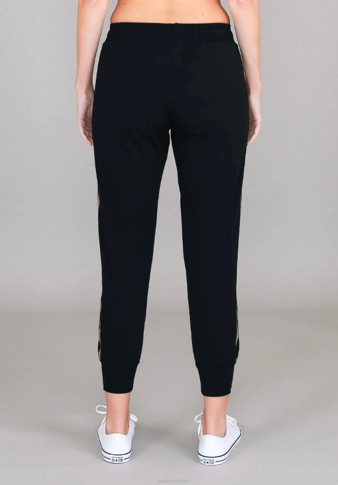3rd Story The Label Gabby Stripe Jogger in Black — back view of black tapered cotton jersey jogger with twin gold metallic side stripes and ribbed ankle cuffs, styled with white sneakers, shop in Australia at Kat and Ko Clothing