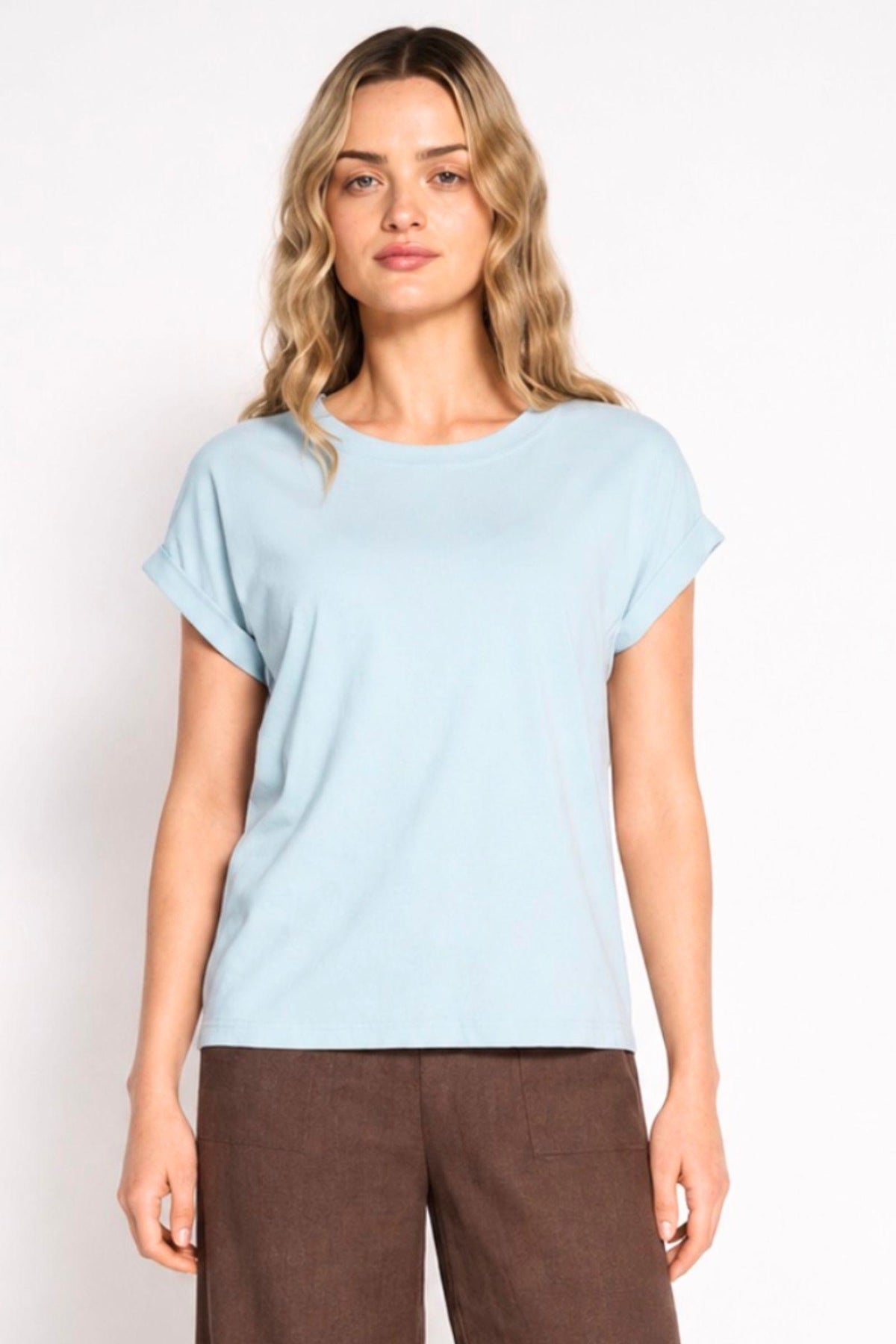 Rhodes Tee in Soft Blue by Little Lies — front half-body view of soft blue short sleeve crew neck tee with rolled cuff sleeves and relaxed fit, styled with chocolate brown wide-leg trousers, shop in Australia at Kat and Ko Clothing