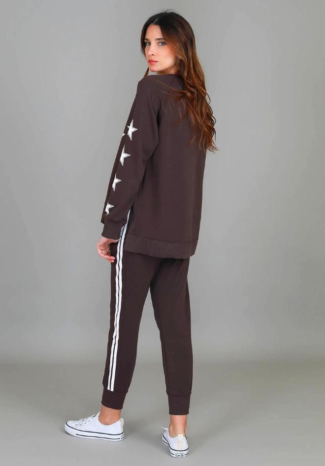 Kate Leopard Star Sweater Truffle 3rd Story The Label — back side profile showing white star accents on raglan sleeves and raw-edge hi-lo hem, styled as a matching set with truffle stripe joggers and white sneakers, available in Australia at Kat and Ko Clothing
