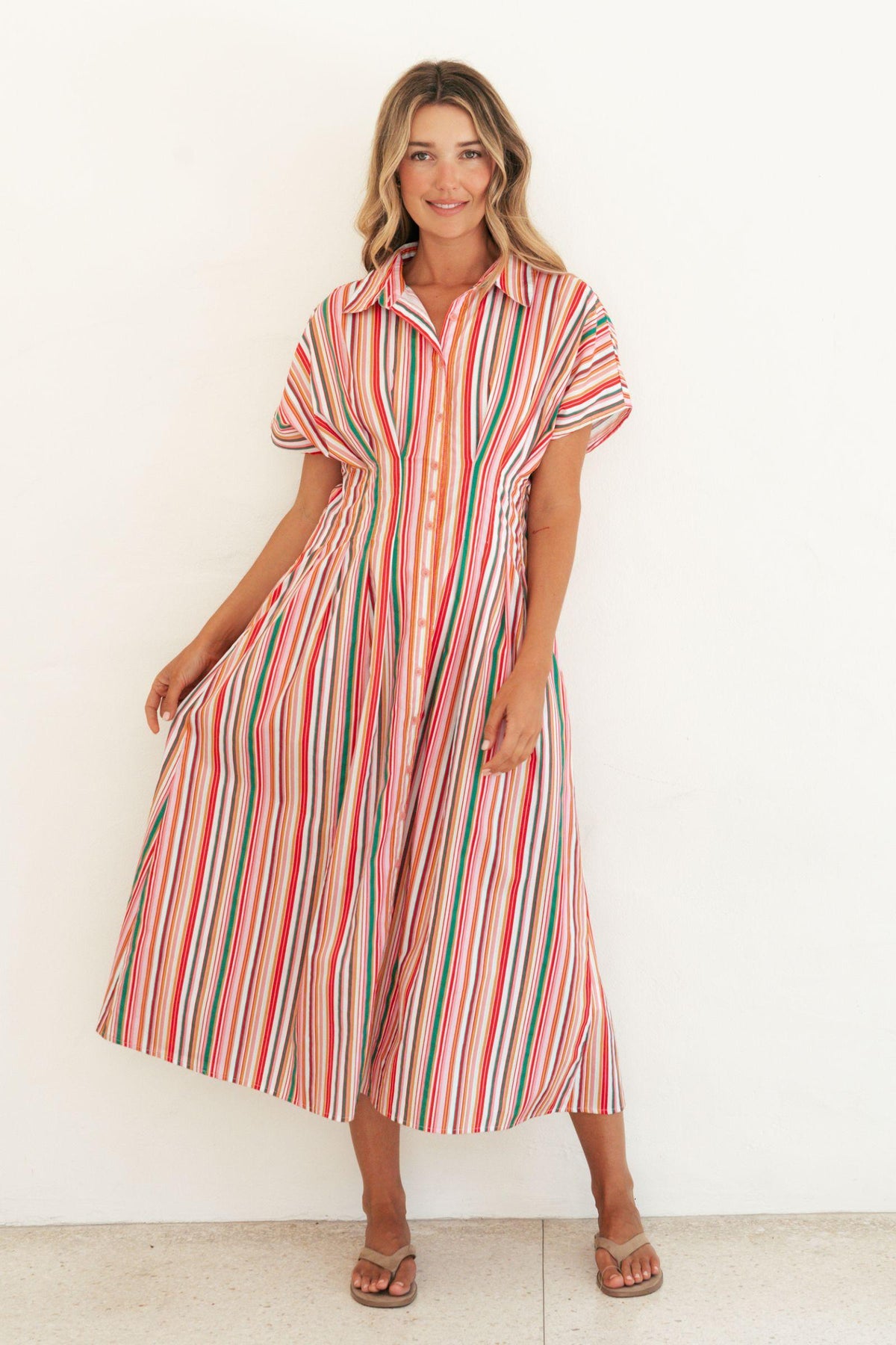 Label of Love Bella Stripe Midi Dress full-length front view, model holding out the flared skirt, with tan sandals