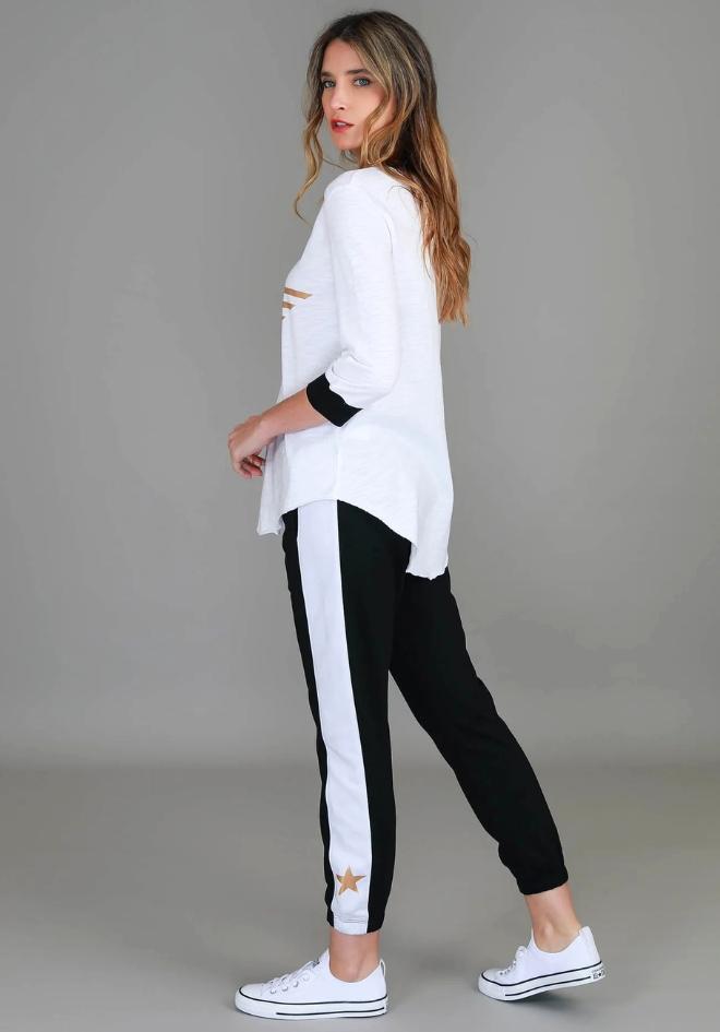 3rd Story The Label Sammie 3/4 Star T Shirt — back side profile showing curved hem and contrast black cuffs on white cotton jersey tee, styled with black and white stripe joggers and white sneakers, shop in Australia at Kat and Ko Clothing