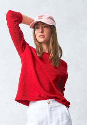 Nellie Top in Red by Little Lies — front view of red long-sleeve knit top with crew neck and relaxed cropped fit, styled with white wide-leg pants and pink cap, available in Australia at Kat and Ko Clothing