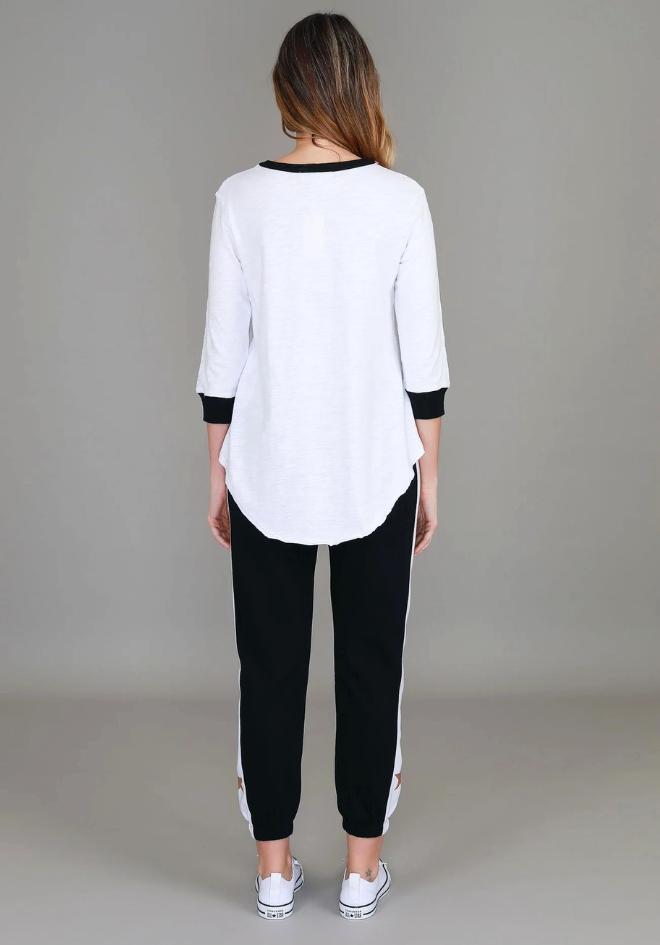 Sammie 3/4 Star T Shirt White by 3rd Story The Label — back view of white relaxed fit cotton tee with contrast black neckline and curved hem, styled with black and white stripe joggers and white sneakers, available in Australia at Kat and Ko Clothing