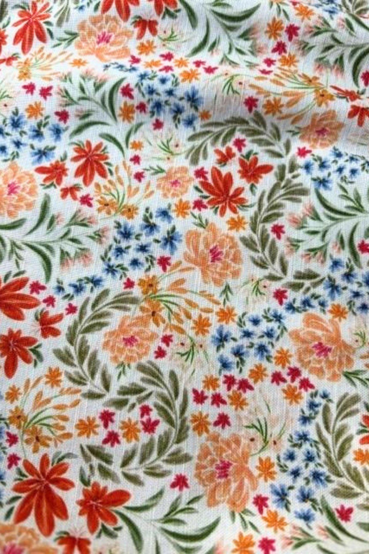 Little Lies Margot Shorts floral print close-up showing orange, blue and green flowers on a white base
