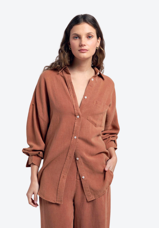 Woman wearing a brown shirt and pants on a white background