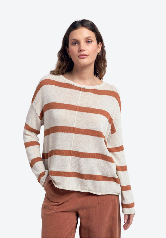Woman wearing a striped sweater and pants on a white background
