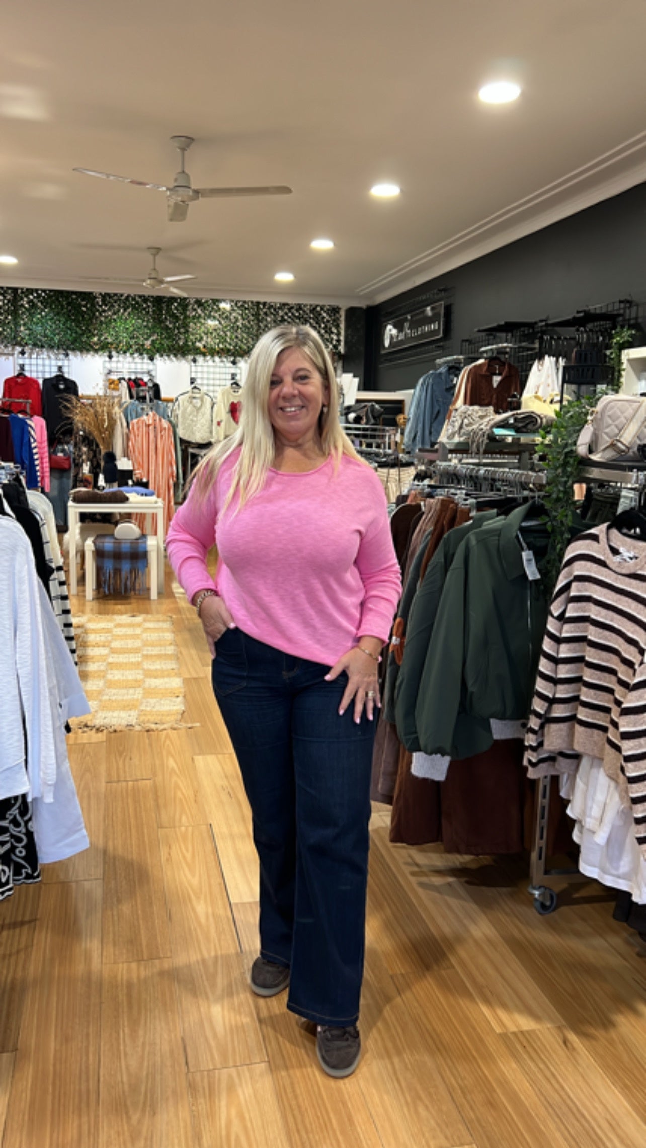 Nellie Top in Candy by Little Lies — in-store full-length view of relaxed fit candy pink long sleeve cotton top with round neckline and straight hemline, styled with dark navy wide-leg jeans, available in Australia at Kat and Ko Clothing