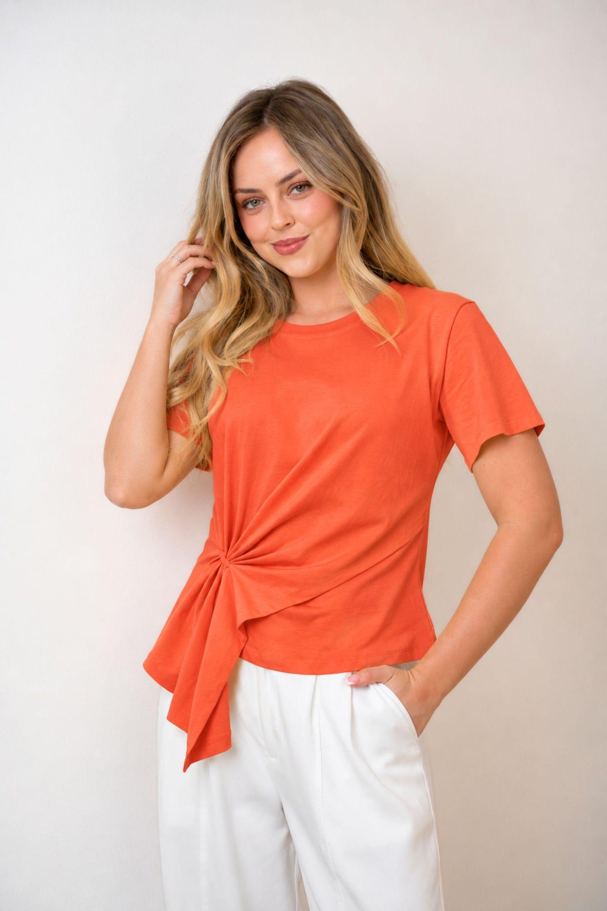 Fria The Label Ellery Ring Detail Tee in Papaya with gathered ring side detail, worn with white pants