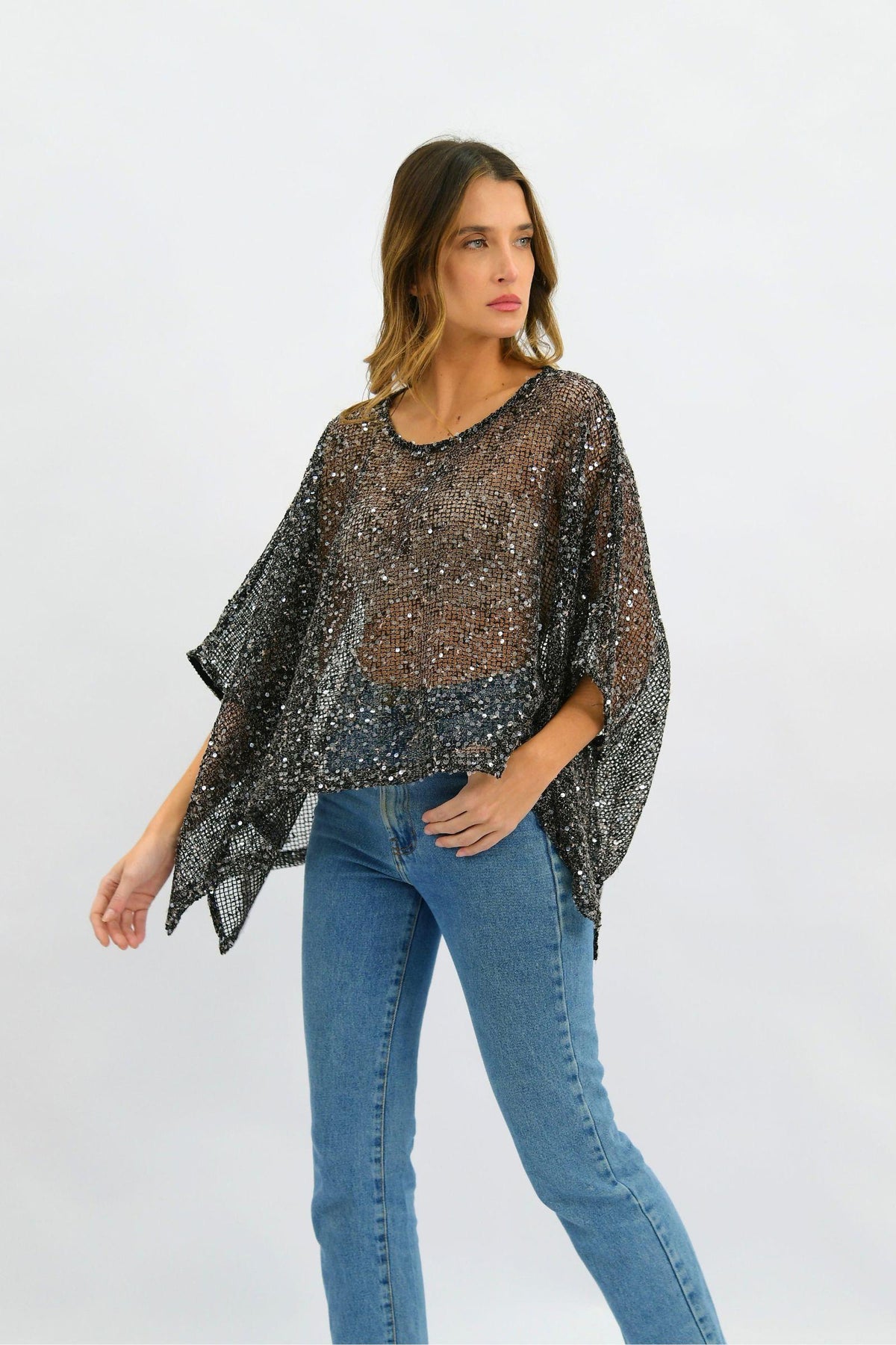 Golden Hour Sequin Top by Worthier — three-quarter front view of the relaxed black all-over sequin top with draped sleeves, styled with blue jeans against a white studio background, available in Australia at Kat and Ko Clothing