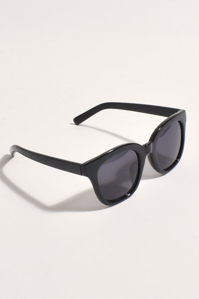 A pair of black full frame sunglasses with dark lenses, positioned to show the front profile.
