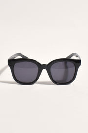 A pair of black full frame sunglasses with dark lenses, positioned to show the front profile.