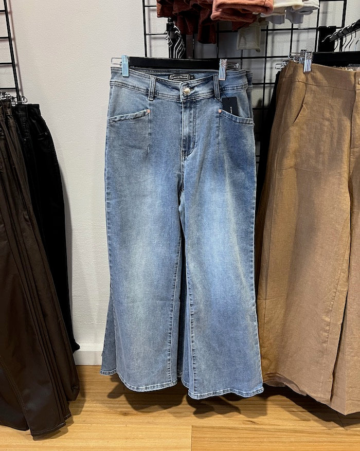 Blue jeans worn by a person on a white background
