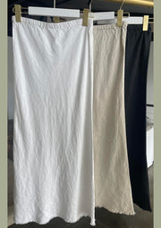 A white linen slip skirt with elastic waistband and frayed hem detailing, displayed on a hanger.