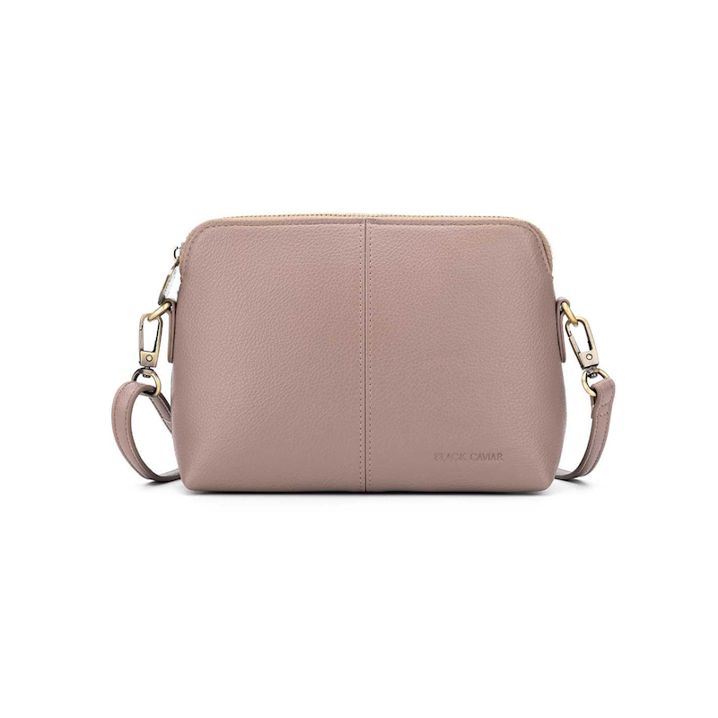 A small mushroom-colored crossbody bag with two straps, a zip closure, and a brushed gold hardware detail.