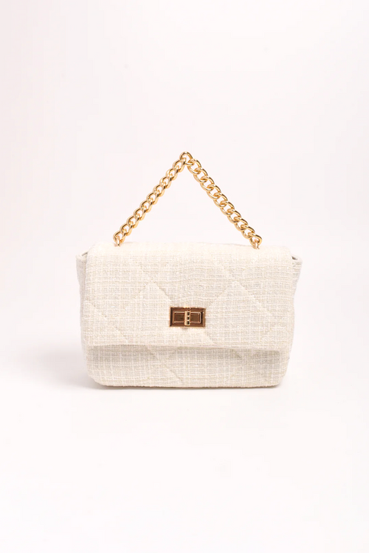 White handbag with gold chain handle on a white background