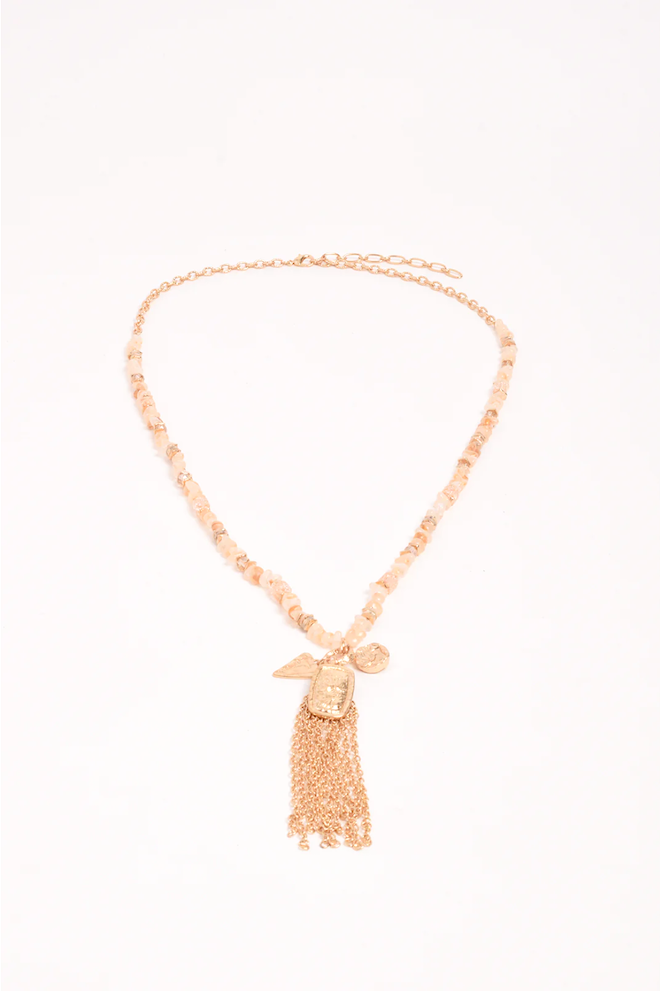 Gold necklace with a tassel pendant on a white background