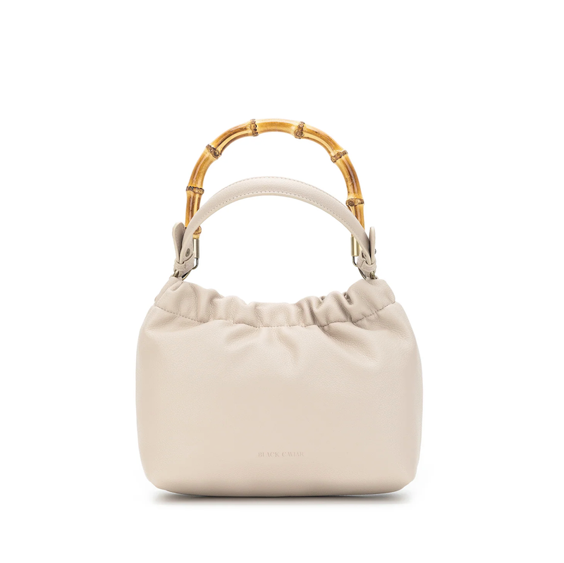 Beige handbag with bamboo handle on a white background