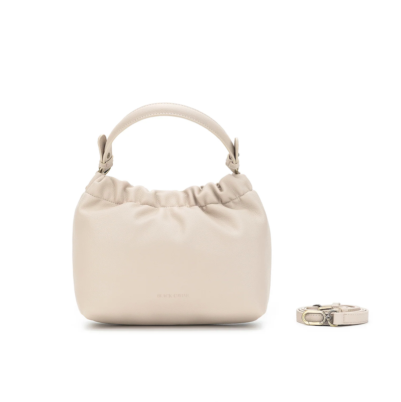 Beige handbag with a matching ring on a white background