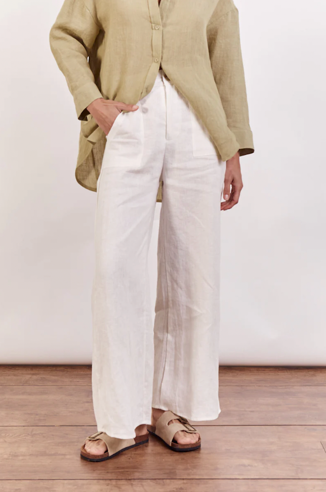 Jude Linen Pants by Little Lies — waist-to-hem detail of white wide-leg linen pants showing zip front and side pockets, styled with a tan linen shirt, available in Australia at Kat and Ko Clothing
