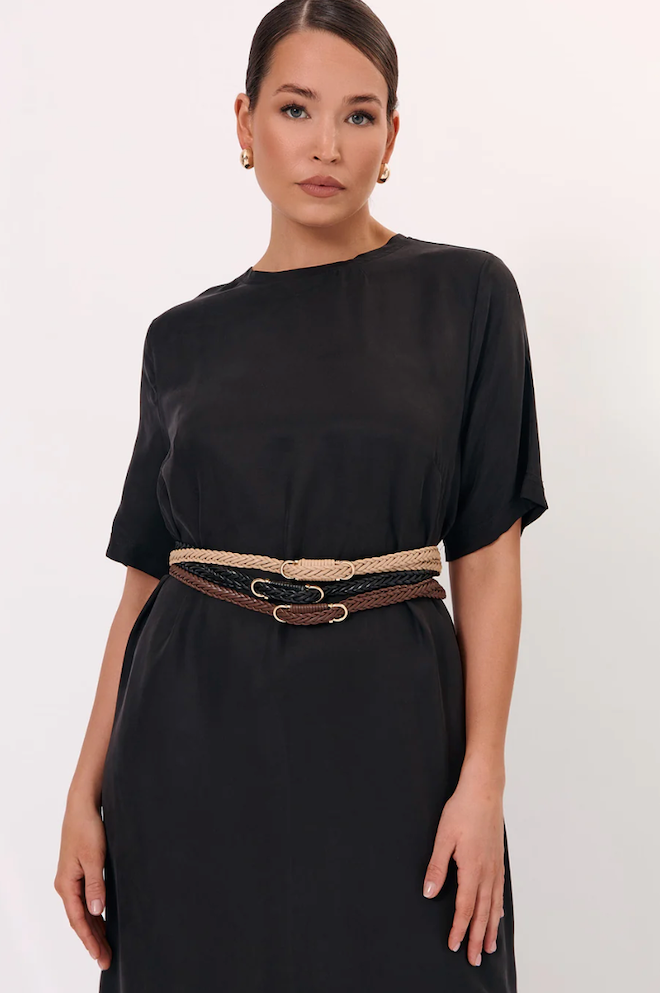 Woman wearing a black dress with a belt on a white background
