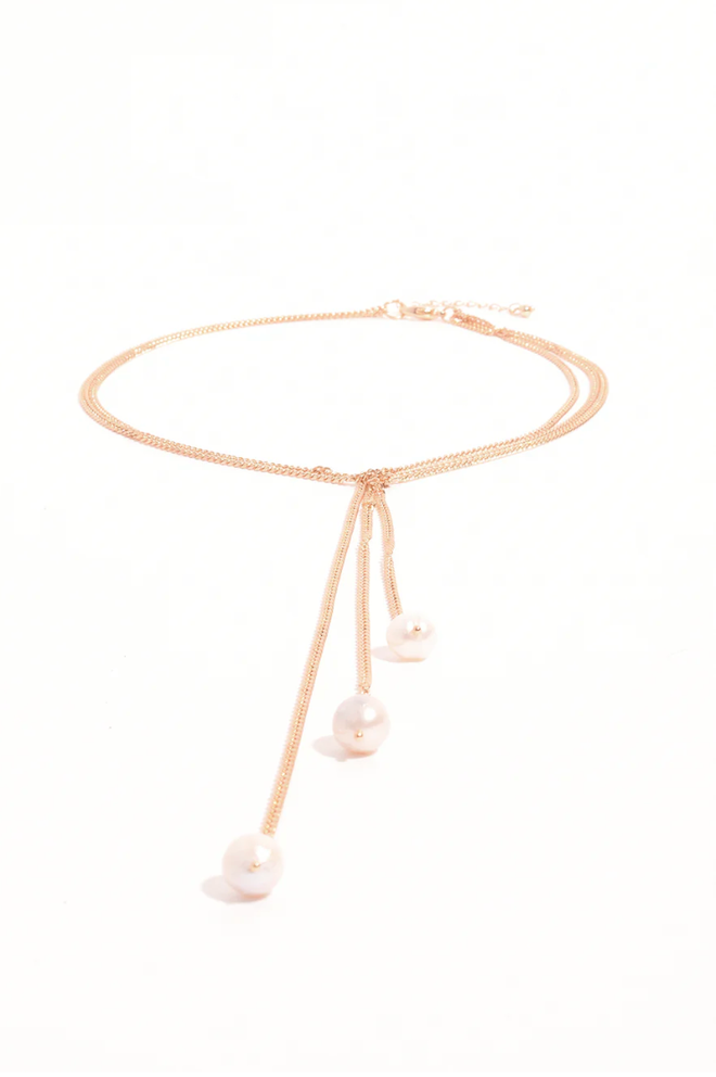 Gold necklace with pearl pendants on a white background