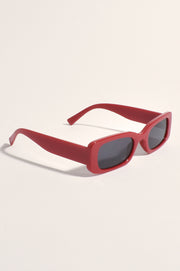 A pair of red sunglasses with a plastic frame and metal temples.