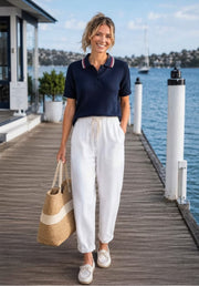 Kat and Ko Clothing navy cotton knitted top with red and white striped collar worn by a woman on a wooden pier.