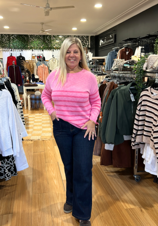 Bobbie Top in Candy Stripe by Little Lies — in-store full-length view of relaxed fit pink and hot pink striped cotton long sleeve top with dropped shoulder, styled with dark navy wide-leg jeans, available in Australia at Kat and Ko Clothing