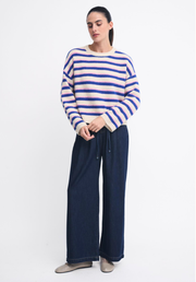 Otto Knit in Pink/Cobalt Stripe by Little Lies — studio full-length front view of relaxed boxy crew neck knit in cream with cobalt and pink horizontal stripes, styled with dark navy wide-leg drawstring pants and silver ballet flats, available in Australia at Kat and Ko Clothing