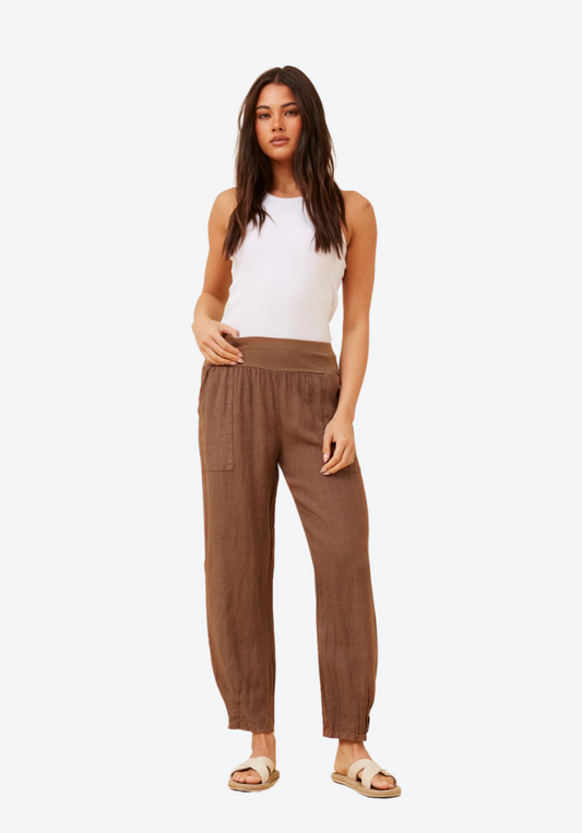 Woman wearing brown pants and a white top on a white background
