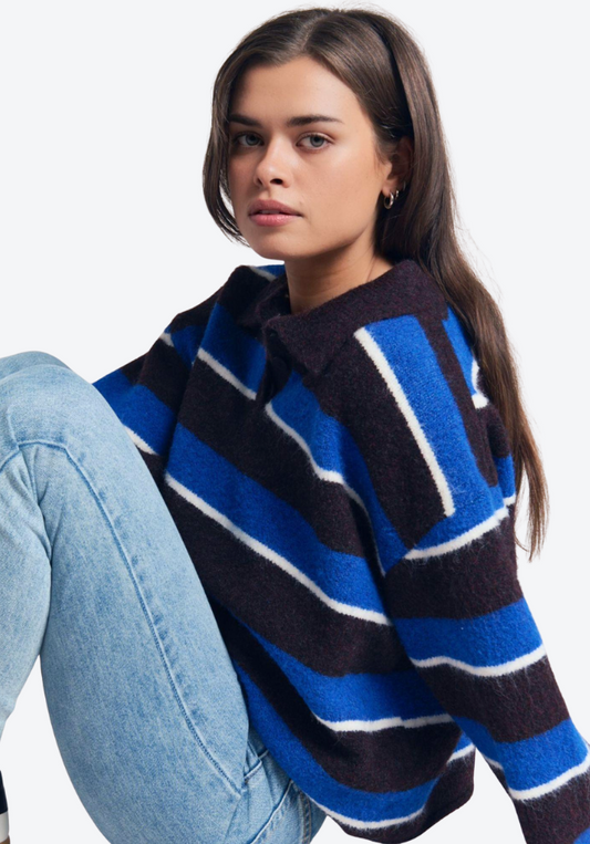 Woman wearing a blue and black striped sweater on a white background
