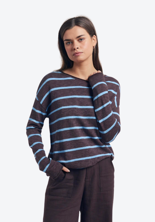 Woman wearing a brown and blue striped sweater on a white background