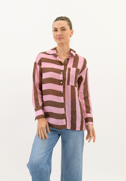 Woman wearing a brown and pink striped shirt with blue jeans on a white background