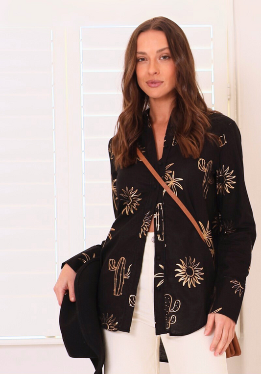 Woman wearing a black patterned jacket with a white background