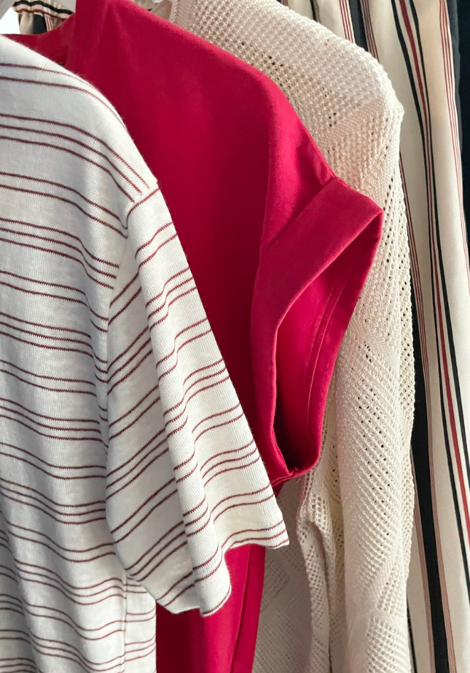 Close-up of a red garment with a white and red striped pattern on a hanger.