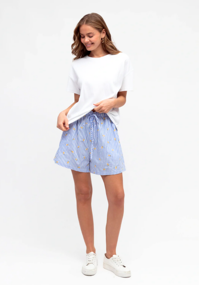 Woman wearing a white t-shirt and blue striped shorts on a white background