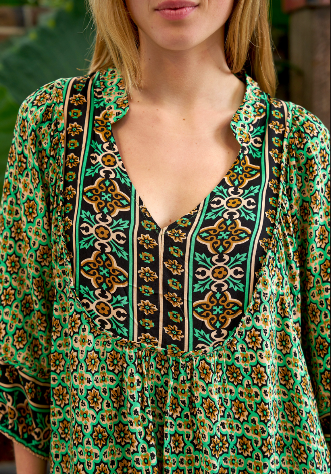 Green patterned blouse with a blurred background