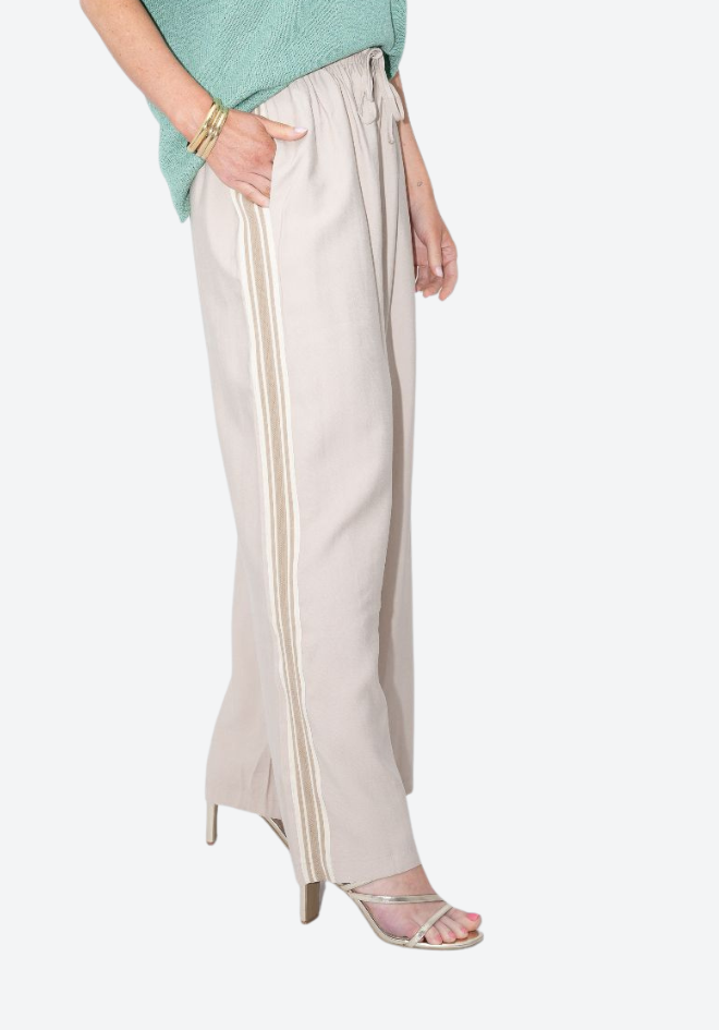 Beige wide-leg pants with white stripes worn by a person on a white background