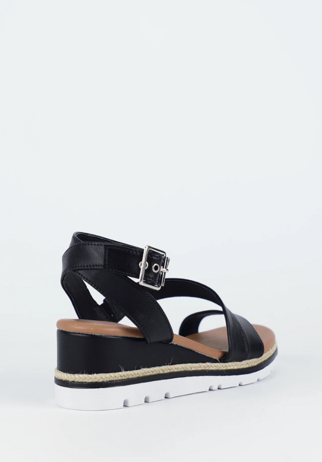Black sandal with a strap and buckle on a white background