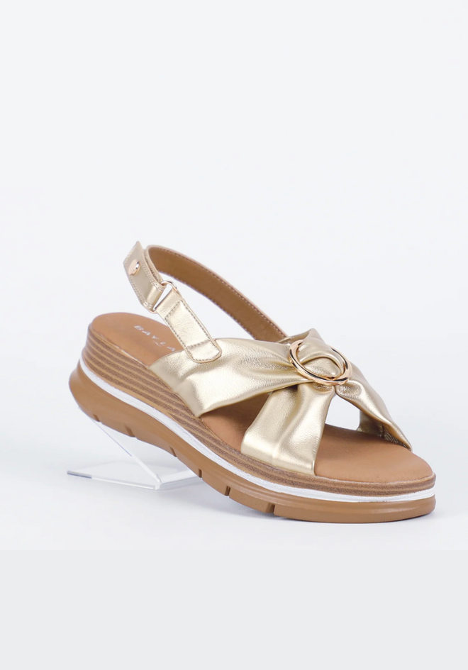 Gold sandal with a bow on a white background