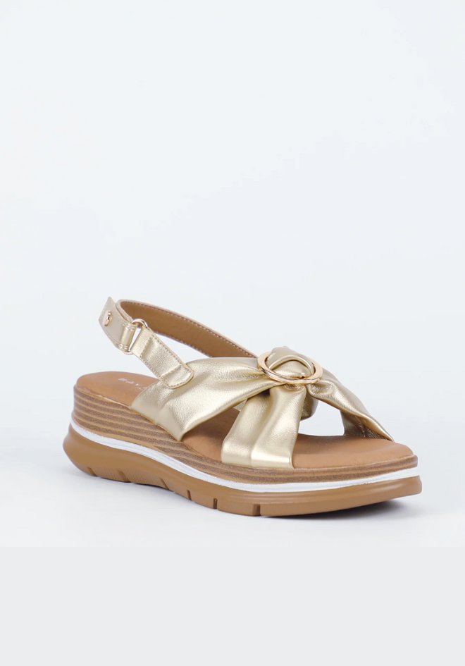Gold sandal with a bow on a white background