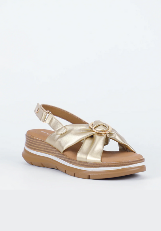 Gold sandal with a bow on a white background